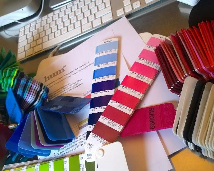 Colour charts and a computer keyboard on a desk in a design studio