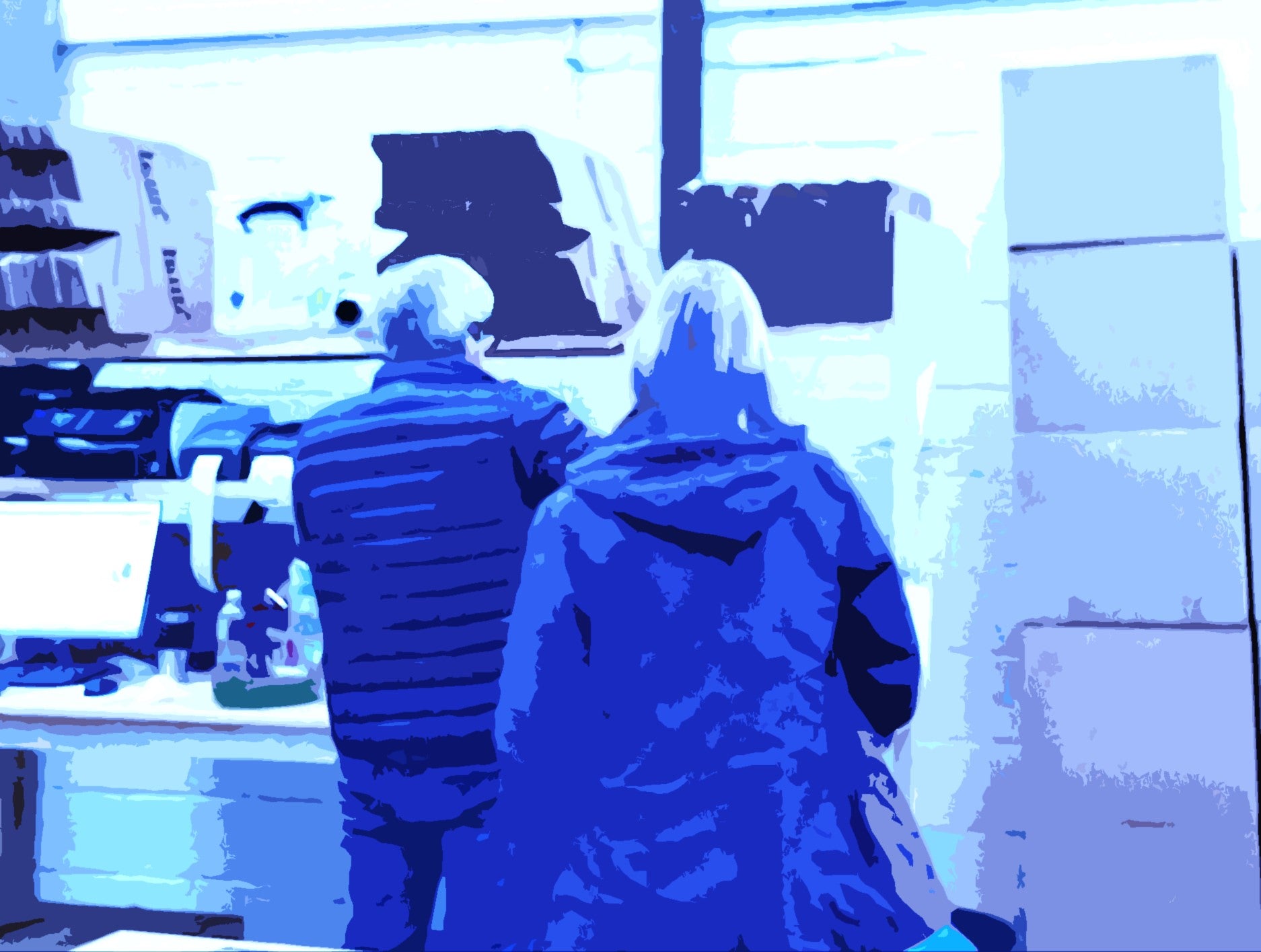 Two people in a warehouse standing by a desk with a blue tint over the image