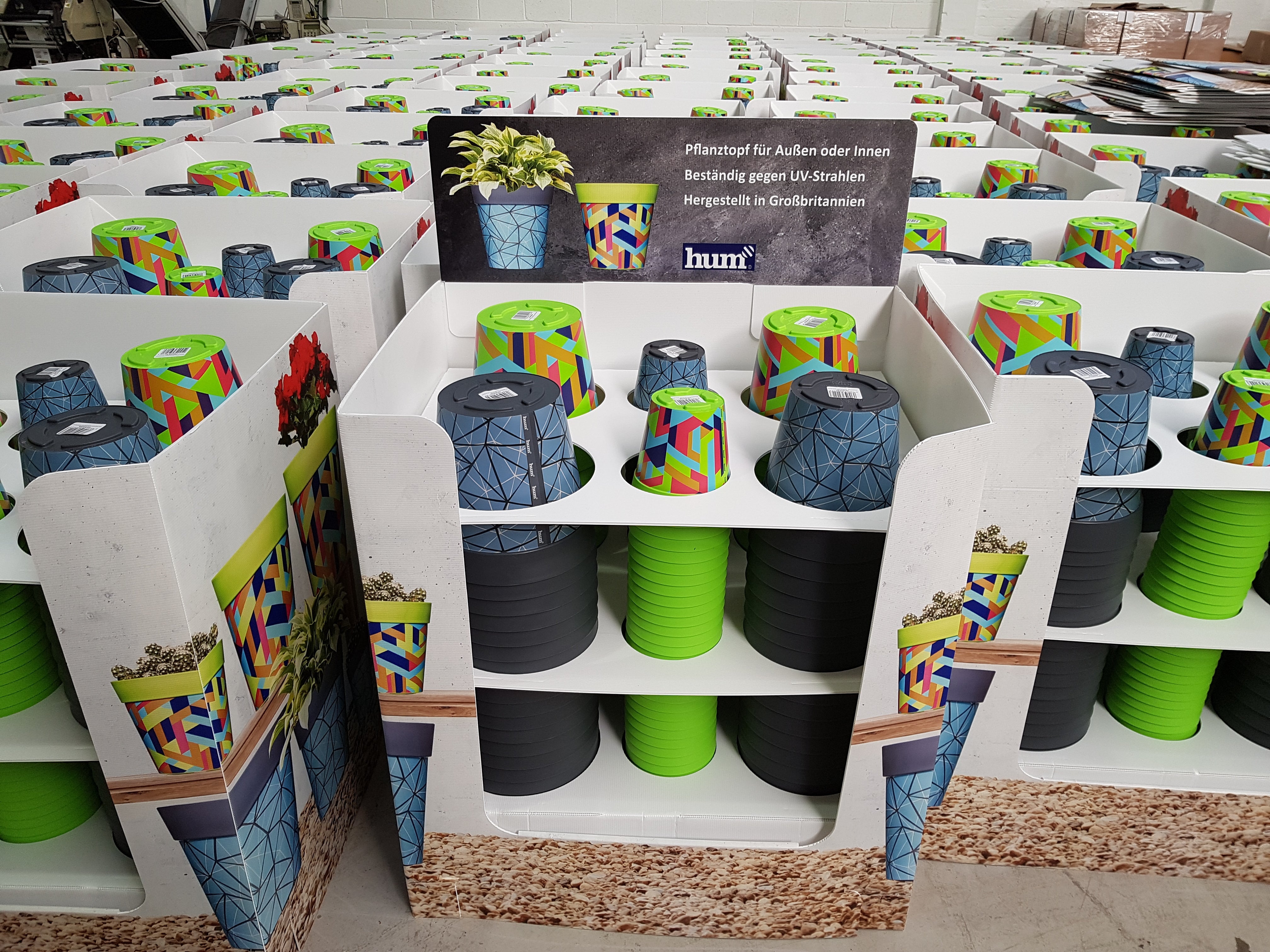 A warehouse packed with display stands full of Hum Flowerpots for retail customers