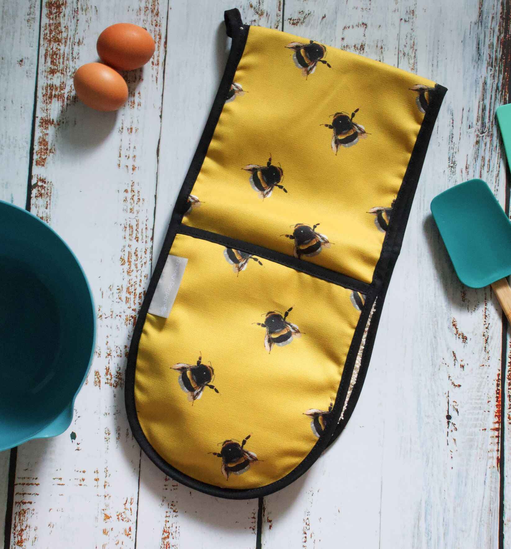 Yellow oven gloves with bee pattern